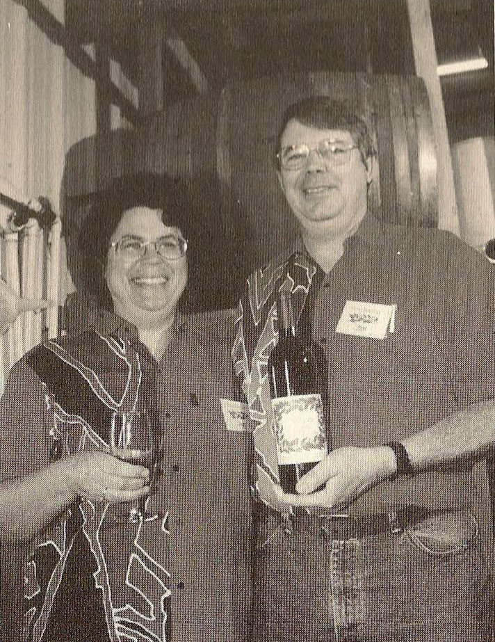 Suzy and Jim Gullett holding a bottle of one of Noceto's earliest vintages of Sangiovese